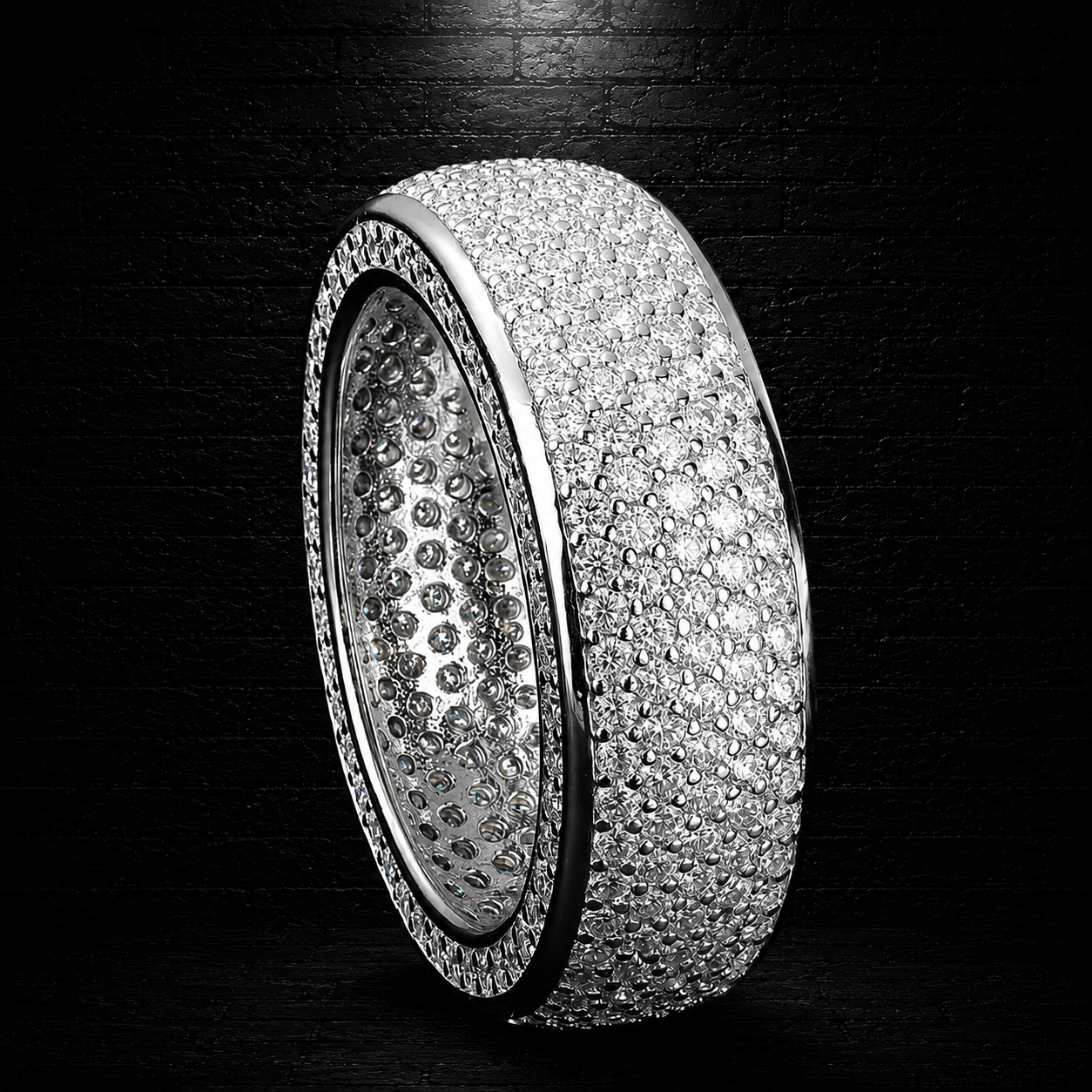 Silver ring with multiple rows of diamonds on a dark background