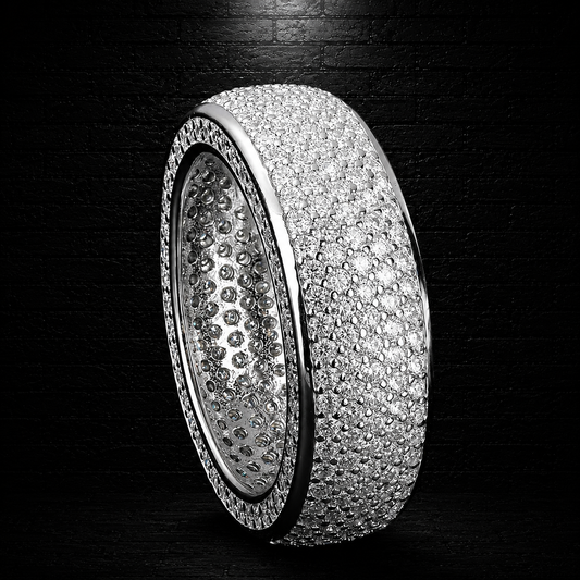 Silver ring with multiple rows of diamonds on a dark background